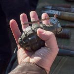 Live WW2 Grenades Found During Estate Sale Hand holding a vintage hand grenade