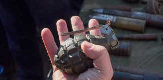 Live WW2 Grenades Found During Estate Sale Hand holding a vintage hand grenade