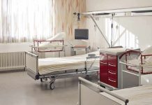 A hospital room featuring empty patient beds and medical equipment