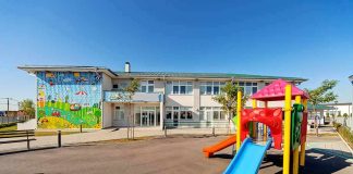 Playground with colorful slide in front of a school building