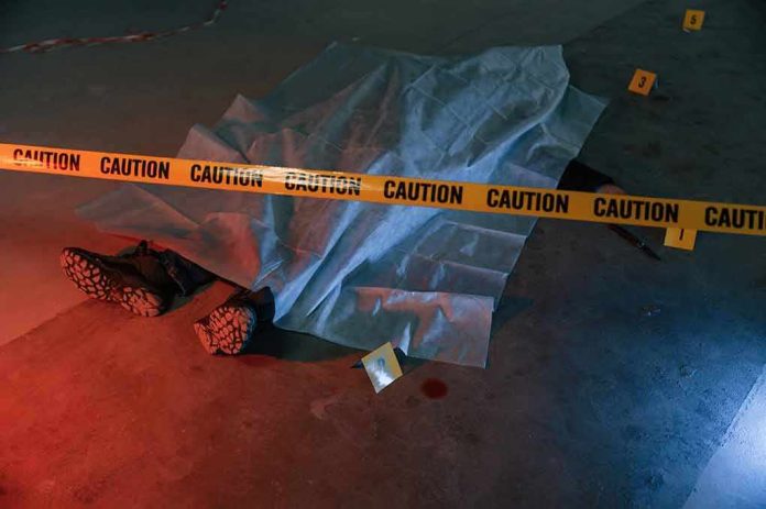 shutterstock_2245205881 crime scene body under sheet behind caution tape