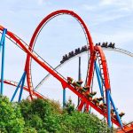 Colorful roller coaster with riders on a sunny day