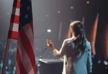 Candidate Holds Rally With Upside-Down Flag American flag and speaker at podium addressing audience