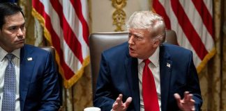 Donald Trump speaks at a meeting table beside Marco Rubio