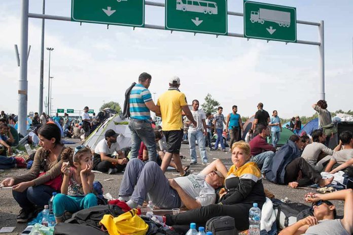 shutterstock_325232072 Group of people resting on a roadway beneath highway signs
